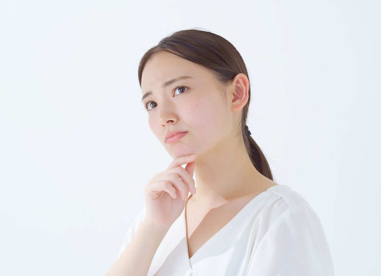 首をかしげて悩む女性